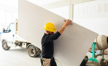 Worker builds a plasterboard wall.